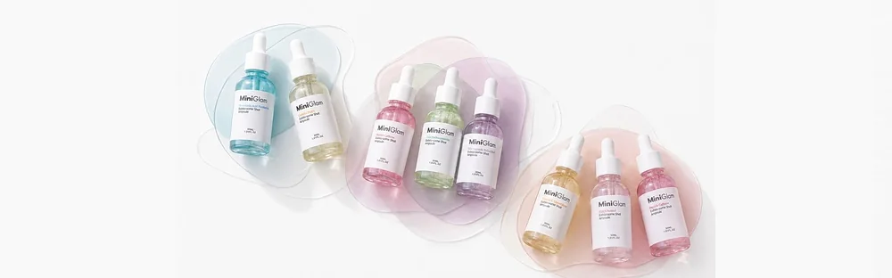 The seven MiniGlam ampoules arranged on pastel shapes